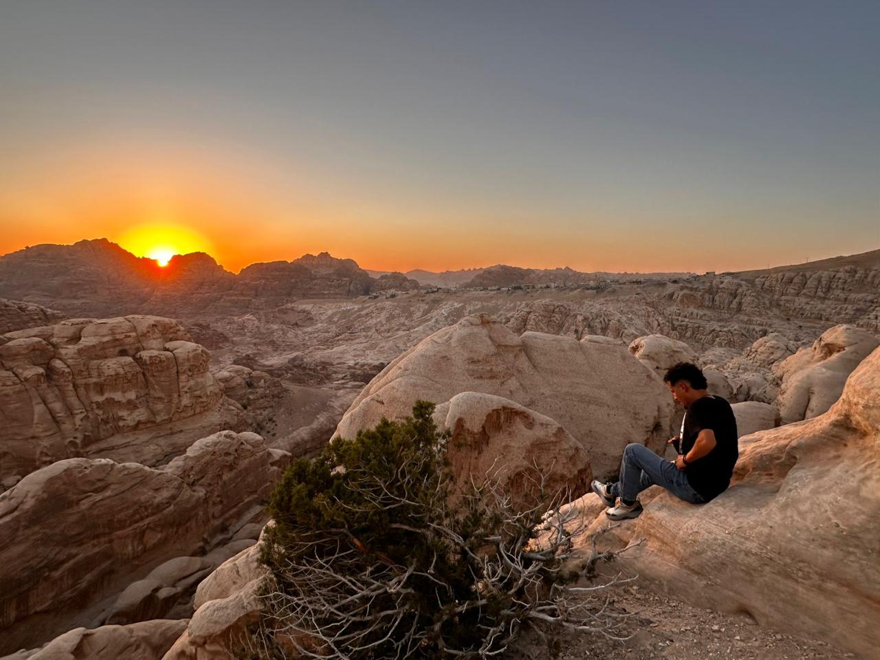 Arsalan sitting on a sandstone viewpoint at sunset